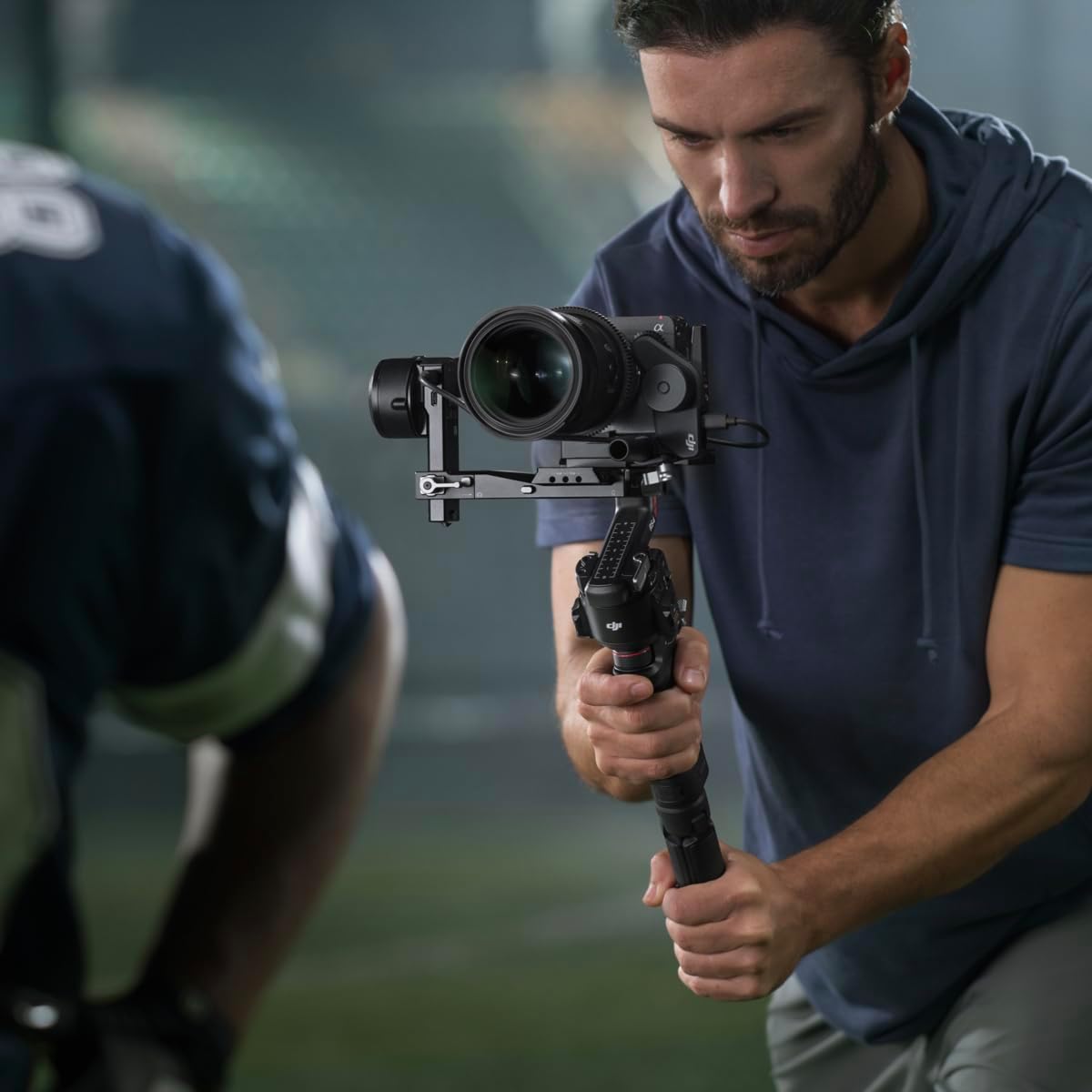 Man holding a camera on a gimbal stabilizer with a blurred background
