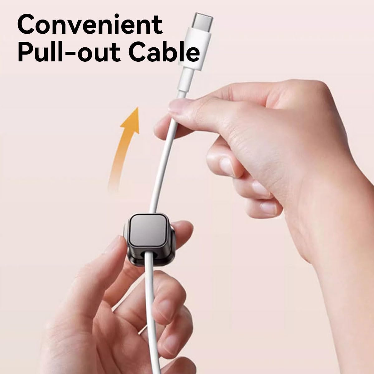 Hand holding a cable with a pull-out feature on a light pink background