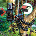 Camera mounted on a flexible tripod with a microphone and screen displaying video, all attached to a tree.