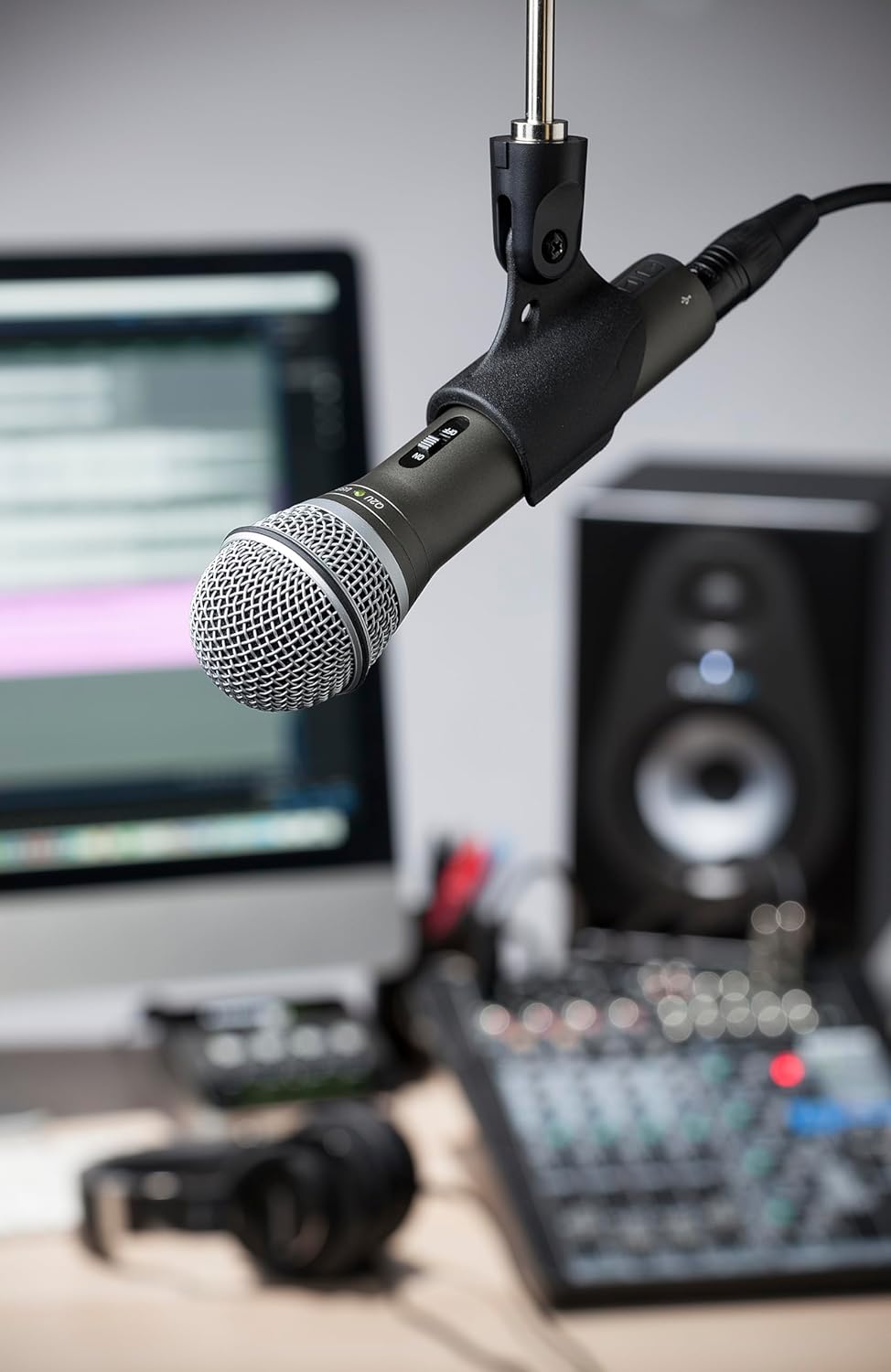 Microphone on a stand with audio equipment in the background