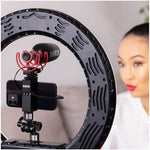 Rig with Rode microphone and phone holder in front of a blurred background with a person.